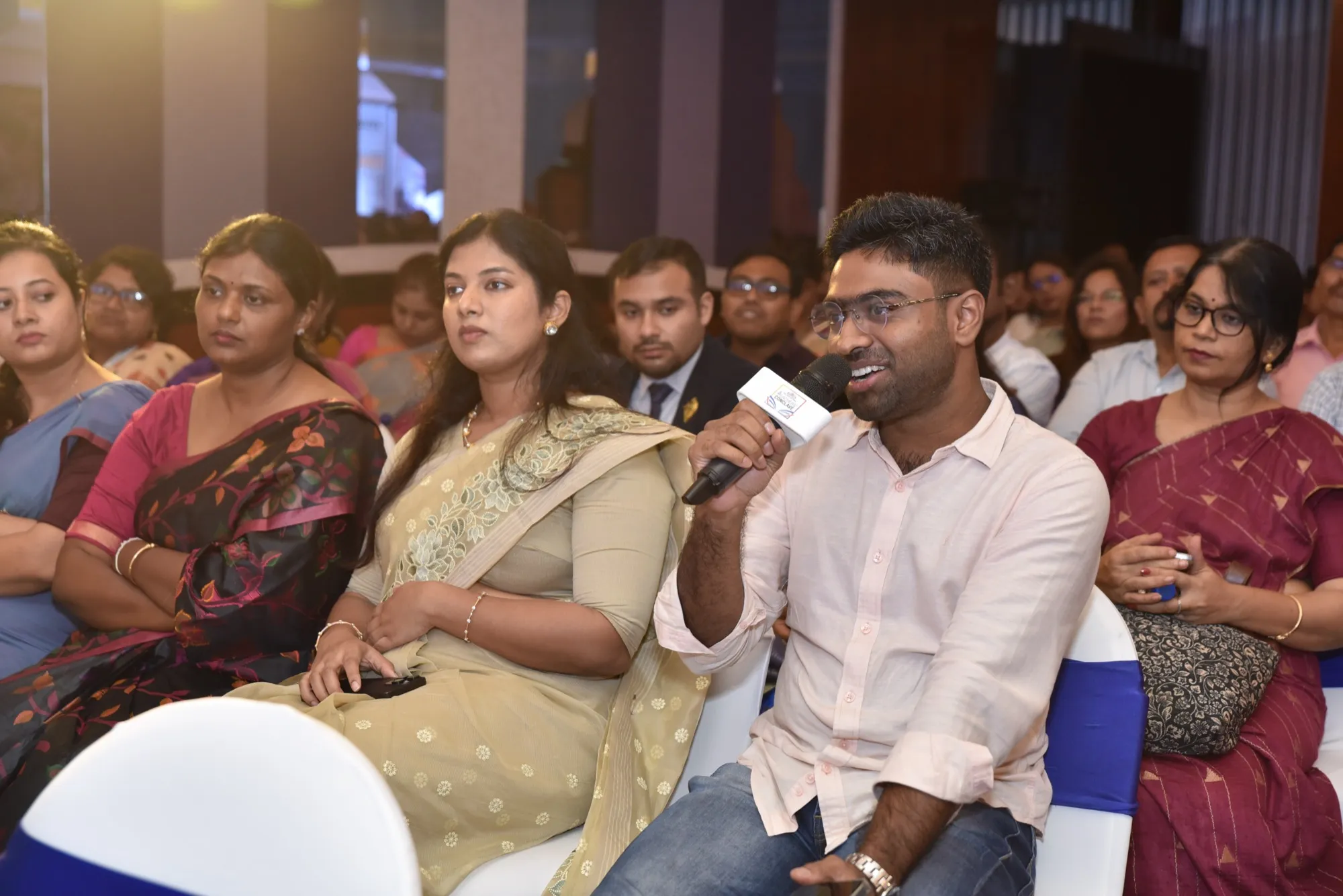 Back in the audience, mic still in hand